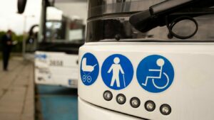 Front of a bus with accessible travel icons showing a wheelchair, pram and person using a walking aid.
