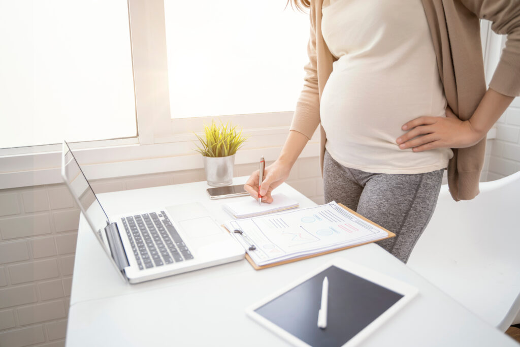 Pregnant women working in a modern office at her desk
