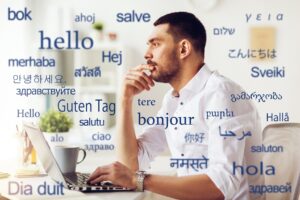 Translation, male translator with laptop thinking over greeting words in different foreign languages